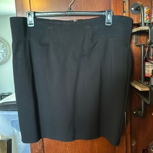 Black fitted skirt. Poly/Nylon/Spandex. Zipper in the back. Elastic waistband.